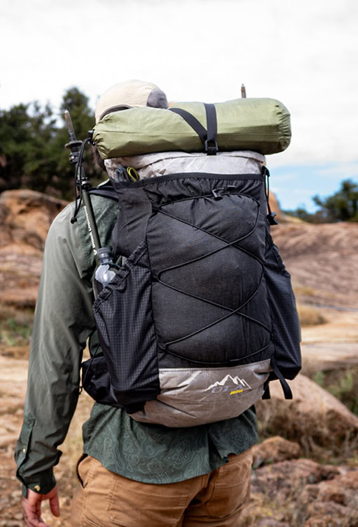 Backpacker puts a Bear Vault Bear Canister into a ULA CDT Backpack