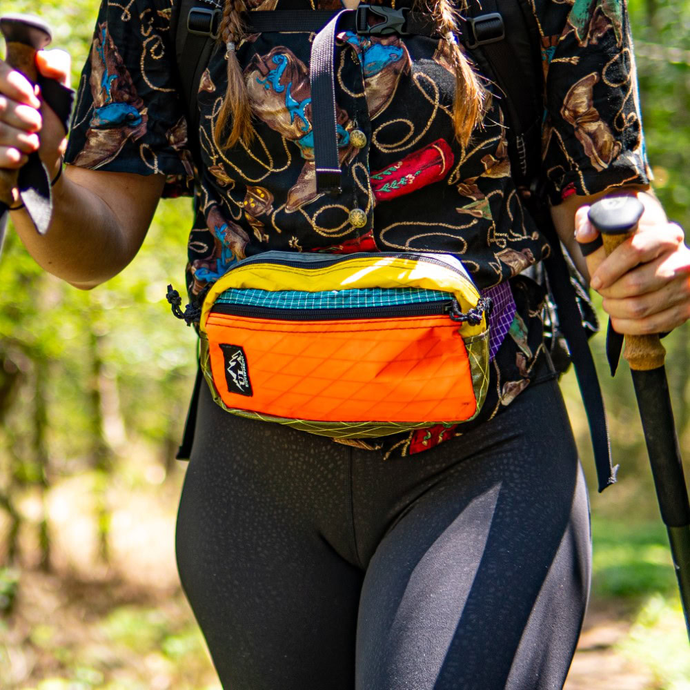 Hiker wears colorful Entropy Spare Tire Waist Pack