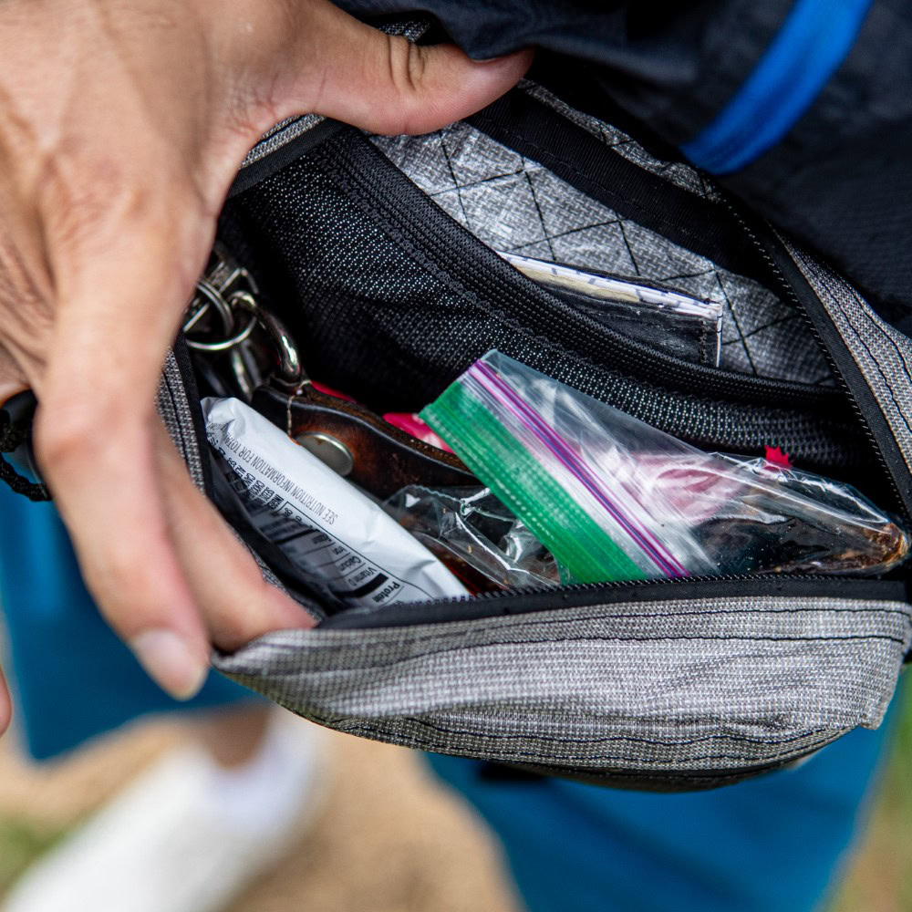 Backpacker looks in spacious inner compartment of ULTRA Spare Tire Fanny Pack