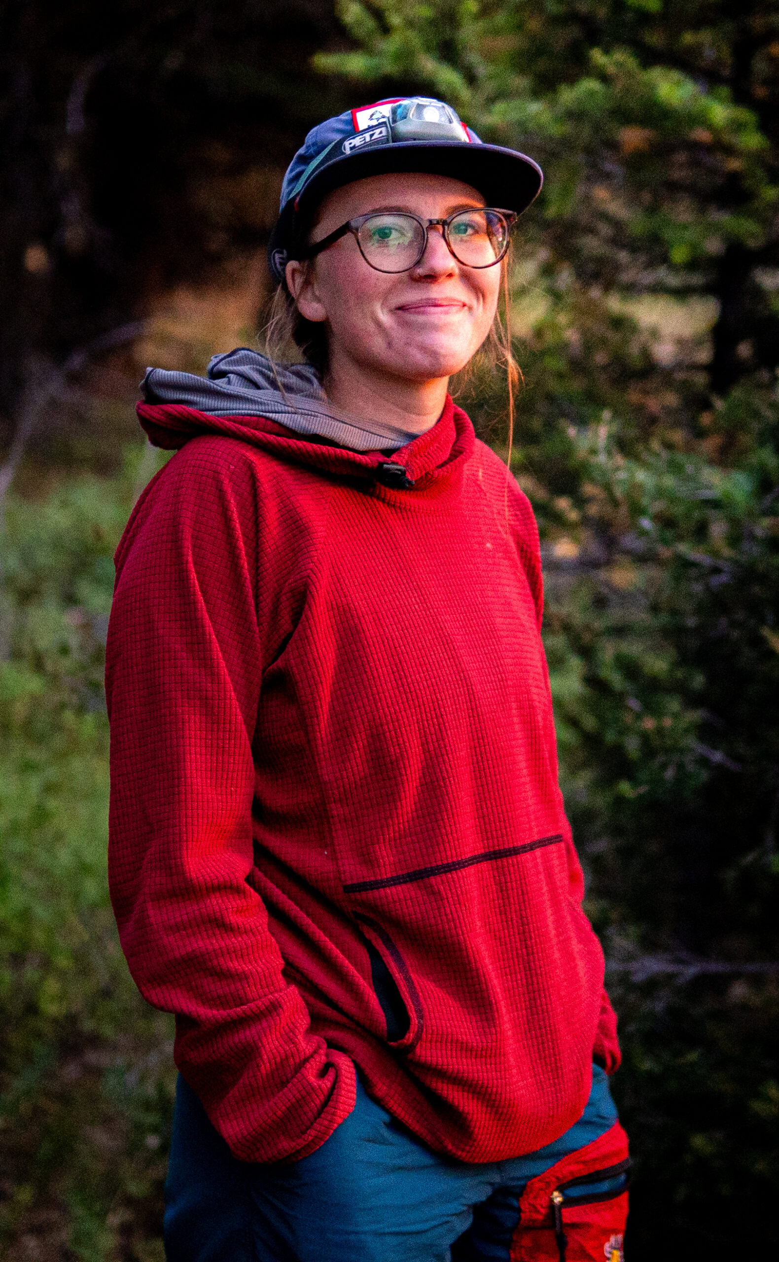 A woman wearing a red sweater smiles at the camera