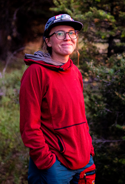 A woman wearing a red sweater smiles at the camera