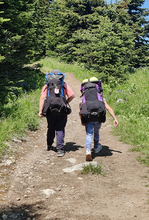 A BearVault being opened by a hiker. The BearVault also keeps your snacks from getting crushed.