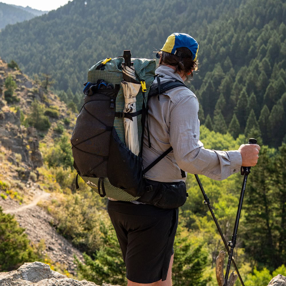 Backpacker on the trail with a ULA Circuit with Bottom Straps carrying a sleeping pad