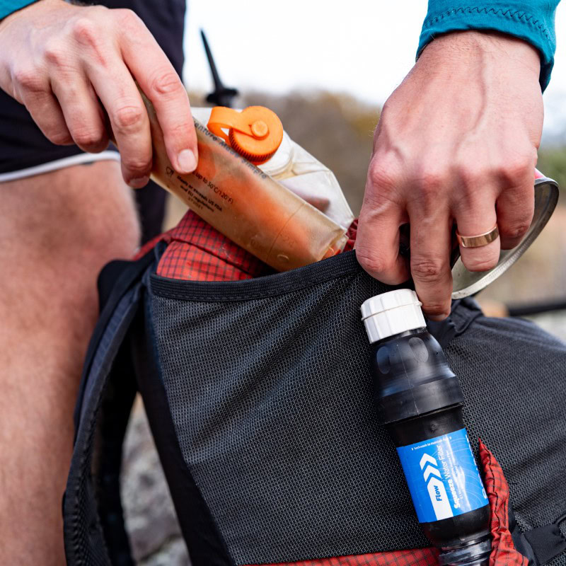 Backpacker on the trail with a ULA Circuit with Bottom Straps carrying a sleeping pad