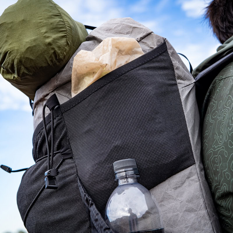 Backpacker on the trail with a ULA Circuit with Bottom Straps carrying a sleeping pad