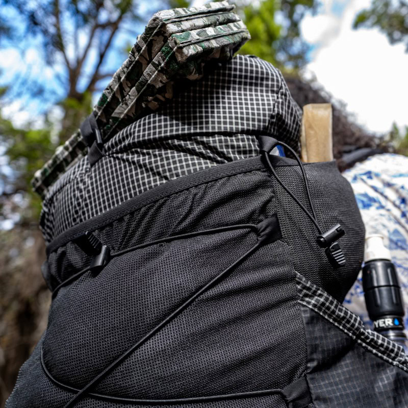 Backpacker tightens top y-strap of Circuit over bear canister