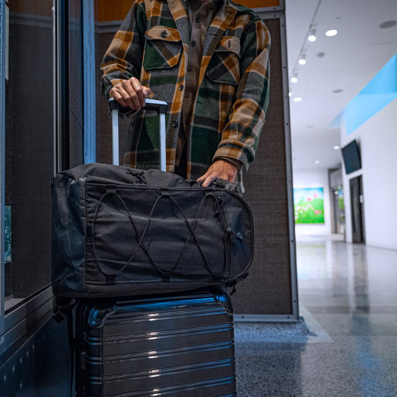 Traveler putting passport in hidden pocket on 30L Dragonfly Pass Thru