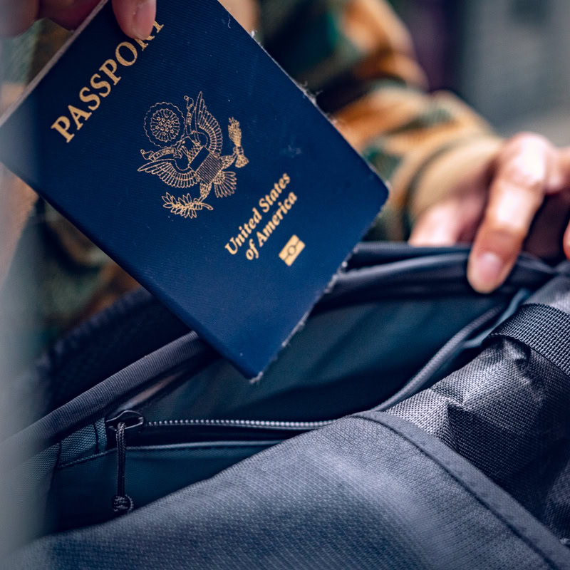 Traveler putting passport in hidden pocket on 30L Dragonfly Pass Thru