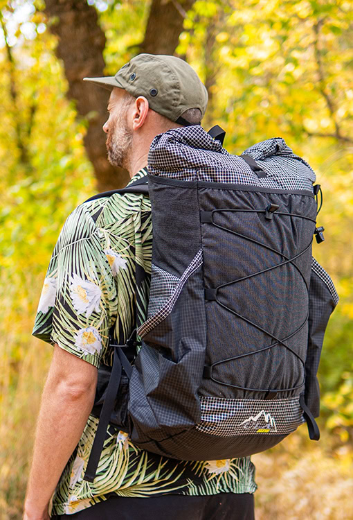 Backpacker puts a Bear Vault Bear Canister into a ULA CDT Backpack