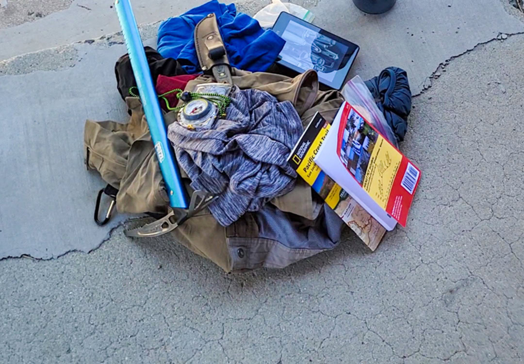 Backpacker reaches for his bear spray from the ULA Deploy Bear Canister Holder on his shoulder strap.