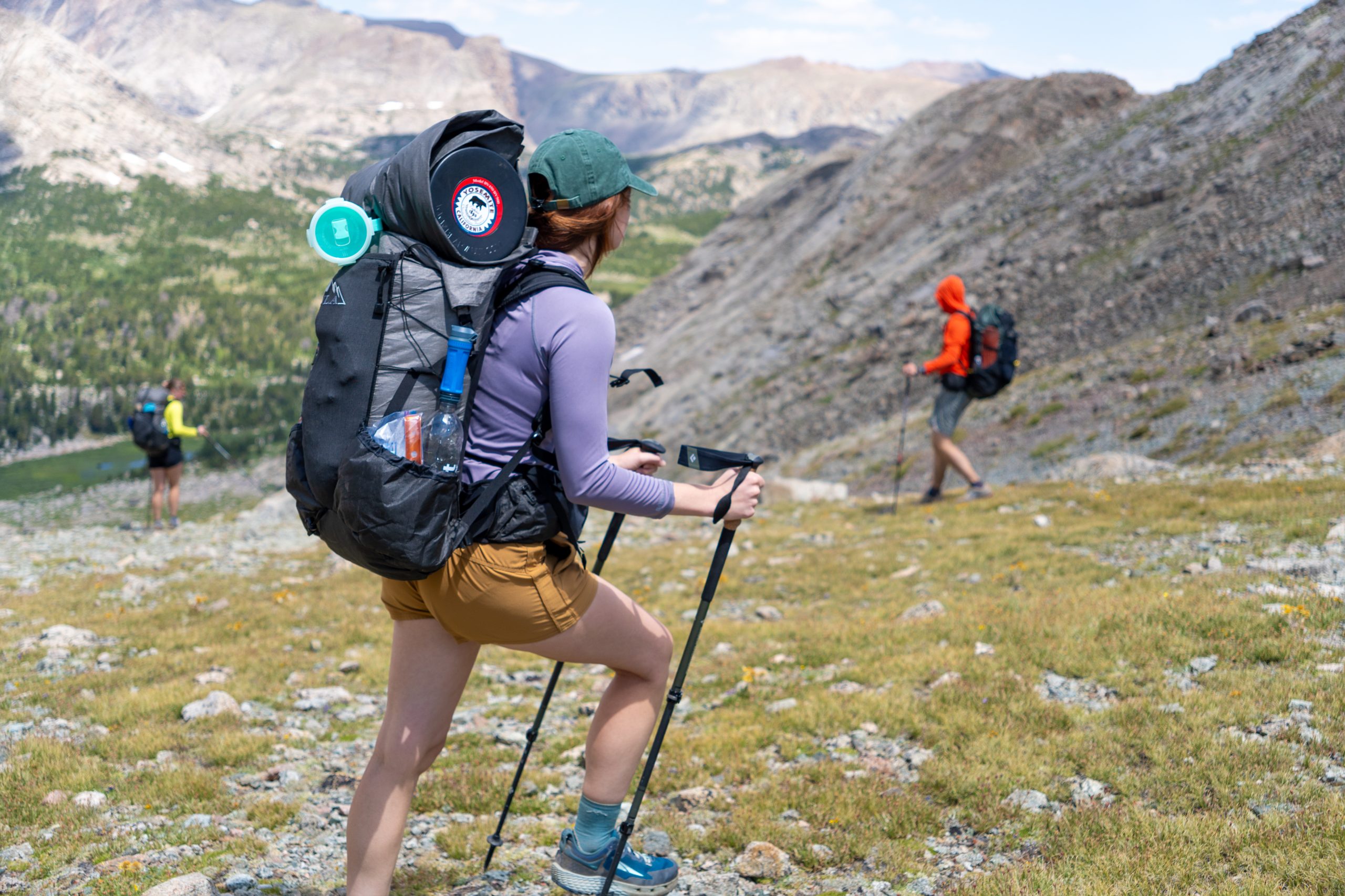 Backpacker reaches for his bear spray from the ULA Deploy Bear Canister Holder on his shoulder strap.